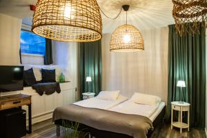 a bedroom with two chandeliers and a bed in it at Hotell Lindgården in Visby