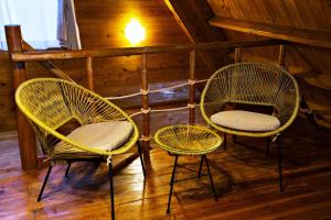 two wicker chairs sitting in the corner of a room at にらい恩納　杉の木 in Onna