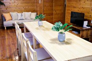 a living room with a table and chairs and a couch at にらい恩納　杉の木 in Onna