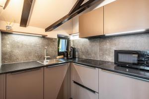 uma cozinha com um lavatório e um micro-ondas em Residence Skutial App Santner em Castelrotto