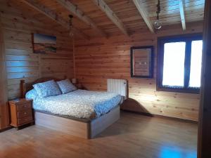 1 dormitorio con 1 cama en una cabaña de madera en El Molino de Candelario, en Candelario