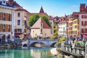 a bridge over a river in a city with buildings at Le Bouvard - MyCosyApart, Central Gare 100m, Netflix in Annecy