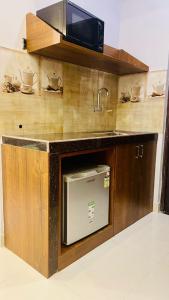 una cocina con fregadero y microondas en Monarch Suites, en Candolim