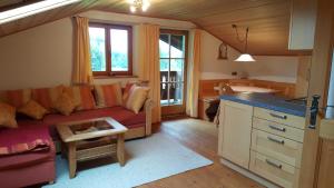 a living room with a couch and a kitchen at Maria Schnitzenbaumer in Fischbachau