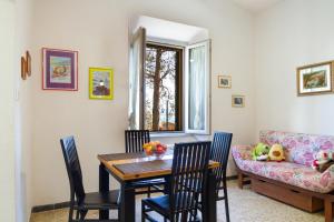 a dining room with a table and chairs and a couch at Casa la Fortezza in Porto Santo Stefano