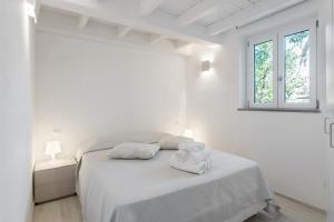 a white bedroom with a bed with towels on it at Casa Carla in Lerici