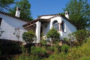 a white house with a tiled roof at Finca Valbono Apartamentos Rurales y Hotel in Aracena