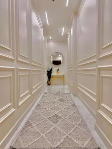 pasillo con paredes blancas, mesa y espejo en شقة فاخرة vip مطلة على البحر برج المسارات, en Yeda