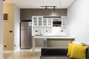 una cocina con armarios grises y un sofá en una habitación en Cozy Flat with Central Location in Moda Kadikoy, en Estambul