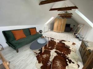 ein Wohnzimmer mit einer grünen Couch und einem Teppich in der Unterkunft Dock Cottage House in Bădeni