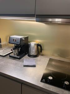 a kitchen counter with a coffee maker on a counter top at Liepaja Apartments in Liepāja