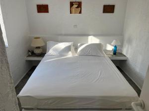a bed with white sheets and pillows in a bedroom at Aegean Dream 3 in Agia Marina