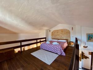 sypialnia z łóżkiem i drewnianą podłogą w obiekcie Tenuta Blancamar Country Bed & Breakfast w mieście Crisionis