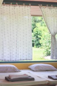 a bedroom with two beds in front of a window at Pai Flora Resort in Pai