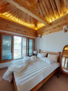 een slaapkamer met een groot wit bed en houten plafonds bij Gyeongju Hanok Sohwa in Gyeongju