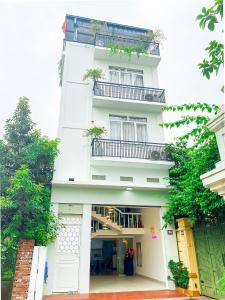 un edificio blanco con balcones y plantas. en Luxury Villa Ha Long en Ha Long