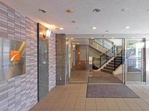 a hallway in a building with a staircase at Chisun Inn Yokohama Tsuzuki in Yokohama