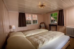 1 dormitorio con 1 cama grande y 2 ventanas en Gasthaus Rössli, en Trogen