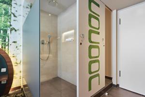 two images of a bathroom with a shower at Cocoon Stachus in Munich
