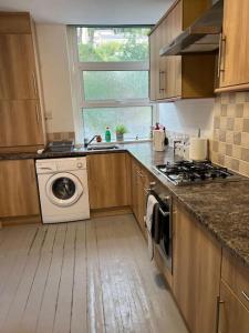 a kitchen with a washing machine and a window at The Old Pie Shop Hebden Bridge in Hebden Bridge