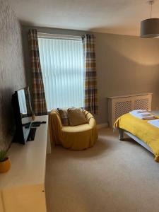 a bedroom with a bed and a couch and a window at The Old Pie Shop Hebden Bridge in Hebden Bridge