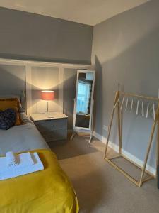 a bedroom with a yellow bed and a mirror at The Old Pie Shop Hebden Bridge in Hebden Bridge