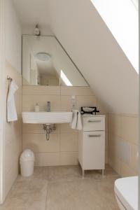 a bathroom with a sink and a mirror at Hotel ten Hoopen Restaurant Deele in Warburg