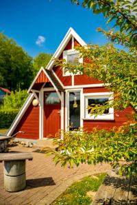 uma casa vermelha com um banco à frente em Nordic Ferienpark Sorpesee em Sundern