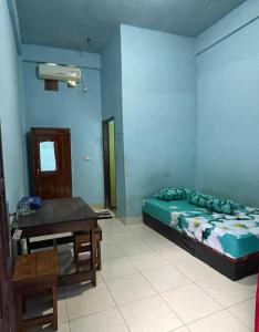 1 dormitorio con cama, escritorio y mesa en EXPRESS O 91669 Kost Amel, en Parepare