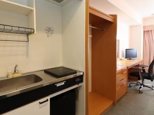 a kitchen with a sink and a desk at Chisun Inn Yokohama Tsuzuki in Yokohama