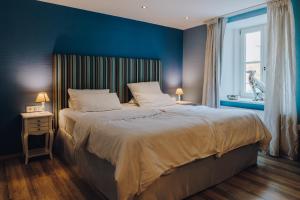雷根斯堡的住宿－Little 7 - Boutique Hotel，一间卧室设有一张蓝色墙壁的大床