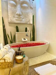 a bathroom with a bath tub and a statue of a face at Moon Villas Umalas in Canggu