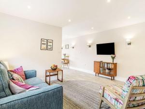 a living room with a couch and a flat screen tv at Wisteria Lodge - Ukc5804 in Shelfanger