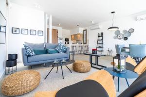 uma sala de estar com um sofá azul e mesas em Cyan 3-Bedroom Villa in Protaras em Paralimni