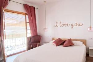 a bedroom with a bed and a sign that reads i love you at Meraki: tu hogar en Frigiliana in Frigiliana