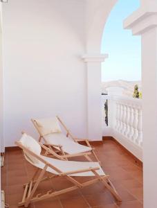 a pair of rocking chairs on a balcony at Meraki: tu hogar en Frigiliana in Frigiliana