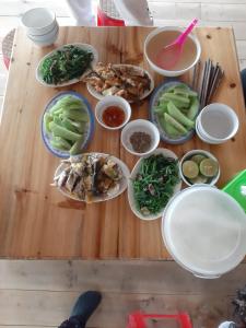 une table en bois avec des assiettes de nourriture dans l'établissement Má Si H'MÔNG HOMESTAY Tả Phìn, à Sa Pa