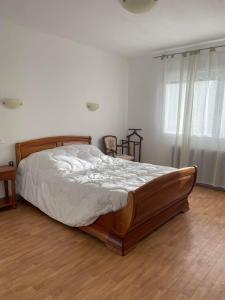 a bedroom with a large bed with a wooden frame at A la casa de papel in Neuilly-sous-Clermont