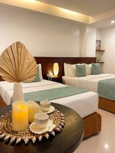 a hotel room with two beds and a table with candles at Jony's Boutique Hotel in Boracay
