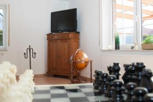 a living room with a television and a chess board at Dat-Steenhuus in Marienhafe