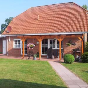 a red brick house with an orange roof at Dat-Steenhuus in Marienhafe