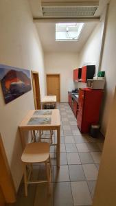 eine Küche mit einem Tisch und einem roten Kühlschrank in der Unterkunft Ferienwohnung am Ring in Baar