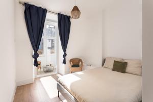 um quarto com uma cama e uma janela em JOIVY Spacious Arroios Flat, Easy Access to the Centre em Lisboa