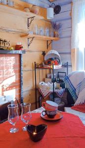 une table avec un tissu de table rouge et des verres dessus dans l'établissement White homestead, à Semeliškės