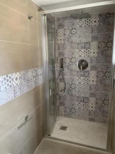 La salle de bains est pourvue d'une douche avec une porte en verre. dans l'établissement Flaviana Salento Holiday House, à Pulsano