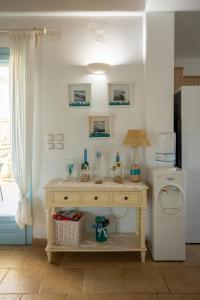 Zimmer mit einem Tisch und einem weißen Kühlschrank. in der Unterkunft Irilena's guest house in Faros