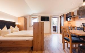 een slaapkamer met een bed, een bureau en een tafel bij Familienbauernhof Samerhof in Pfarrwerfen