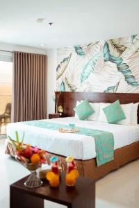 a bedroom with a large bed with a table with fruit on it at Jony's Boutique Hotel in Boracay