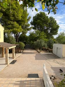 un vialetto con cancello e alberi sullo sfondo di Casa Rústica ad Albacete