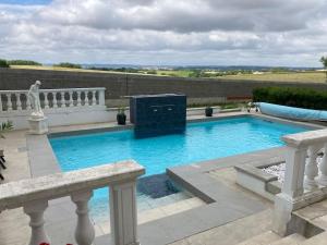 a large swimming pool in a backyard with a fence at Gîte Ardoise in Castelnaudary